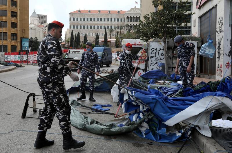 Lebanese security forces pull down tents as they clear away a protest camp and reopened roads blocked by demonstrators since protests against the governing elite started in October, in Beirut. REUTERS