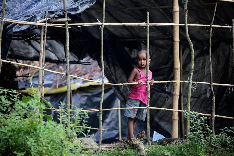 A Rohingya refugee child stands in front of their makeshift tent in Tombru, Banderban, Bangladesh. Abir Abdullah / EPA