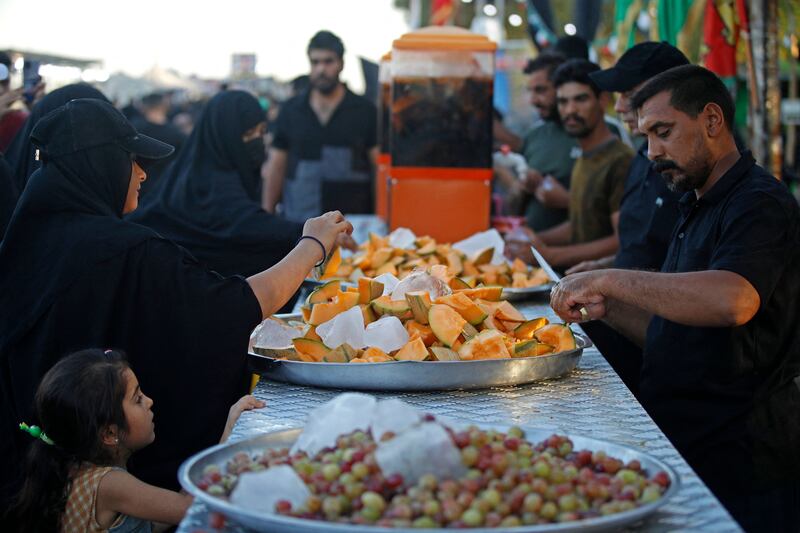 Men distribute fruits to Shiite Muslim pilgrims marching from Baghdad towards the shrine city of Karbala.
