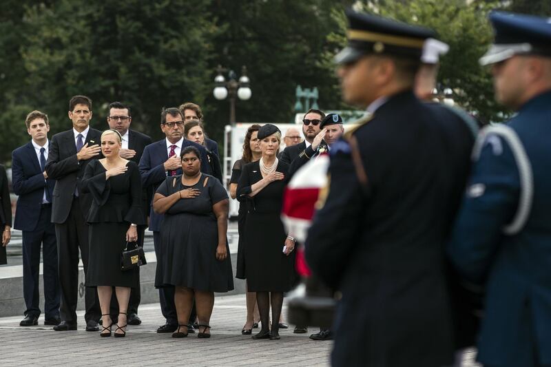 The family of Sen. John McCain, front row from left, Meghan McCain, Bridget McCain and Cindy McCain, watches as his casket is carried to a hearse from the US Capitol in Washington, in Washington, for a departure to the Washington National Cathedral for a memorial service.  AP