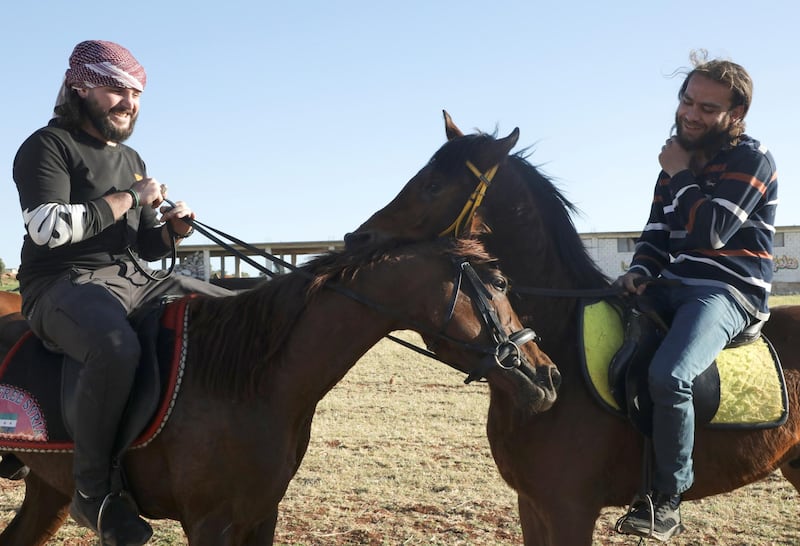 Hussein Rahmoun, right, and a fellow rider at a horse club in Idlib, Syria. Reuters