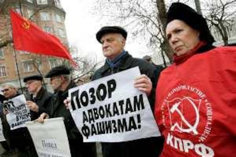 Communist demonstrators hold slogans reading No to revision of Soviet contribution into the World War II victory, and a red flag during a protest at the Polish Embassy in Moscow, Friday, April 6, 2007. Several dozens demonstrators protested against a delay of the opening of a Russian exhibit at the former Nazi death camp of Auschwitz in Poland. Demonstrators like this would potentially get in trouble in Poland in the future for openly displaying communist symbols. (AP Photo/Alexander Zemlianichenko)
