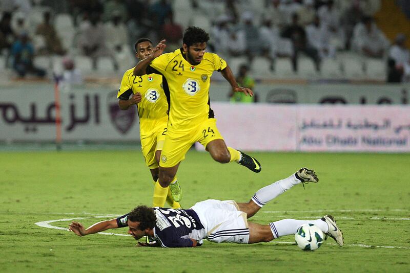 AL AIN , UNITED ARAB EMIRATES Ð Nov 3 : Alex Brosque ( no 32 in blue ) of Al Ain and Rashed Essa ( no 24 in yellow ) of Al Wasl in action during the etisalat pro - league football match between Al Ain vs Al Wasl club at Tahnoun Bin Mohammed Stadium in Al Ain. ( Pawan Singh / The National ) For Sports.