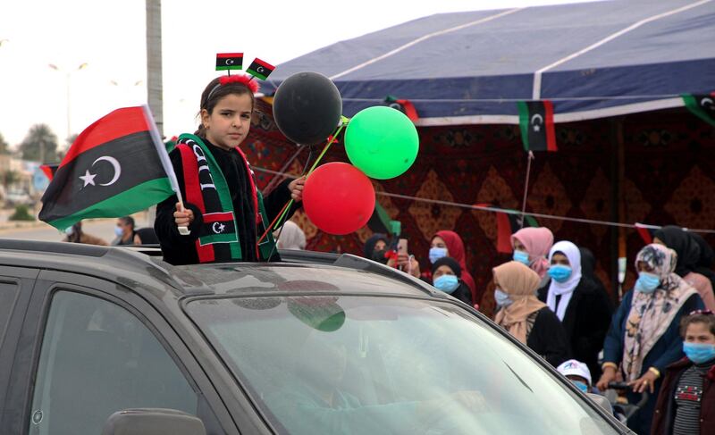 A girl waves a national flag from a car as people gather in Tripoli to celebrate. AFP