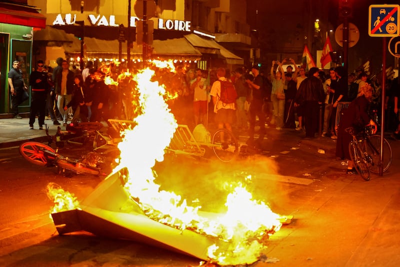 A barricade burns in Paris as election results suggest the far-right National Rally has a first round advantage from French voters. Reuters