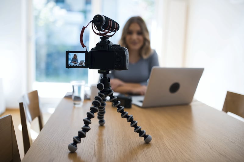 A young vlogger working on her laptop and vlogging herself