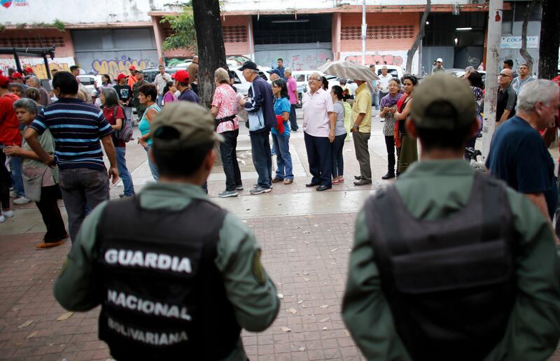 Supporters of Venezuela's President Nicolas Maduro line up to cast their ballots during a test in preparation for the election of members of a constitutional assembly in Caracas, Venezuela, Sunday, July 16, 2017. Venezuela's opposition called for a massive turnout in a symbolic rejection of President Nicolas Maduro's plan to rewrite the constitution, a proposal that's escalating tensions in a nation stricken by widespread shortages and more than 100 days of anti-government protests. (AP Photo/Ariana Cubillos)