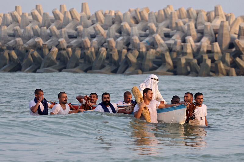 Kuwaiti divers make their way to the main beach during the annual pearl diving festival in Kuwait City on August 17, 2023.  (Photo by YASSER AL-ZAYYAT  /  AFP)