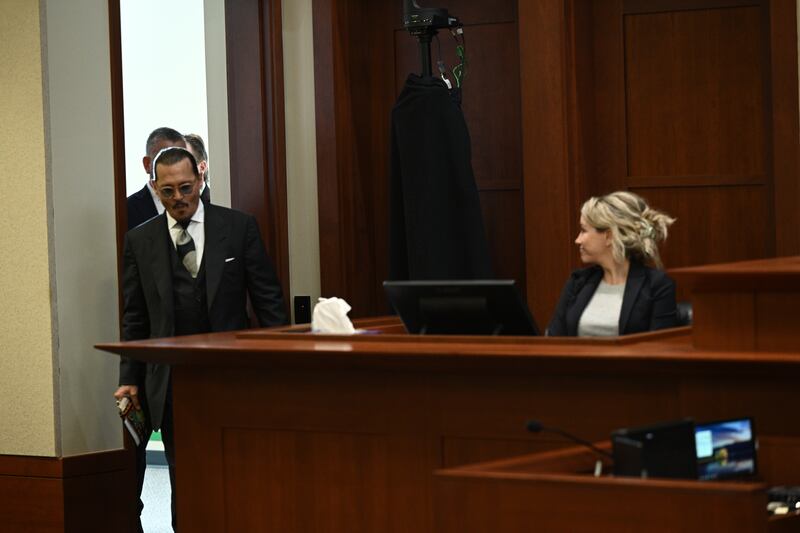 Depp walks past Dr Curry who testified on his behalf. EPA