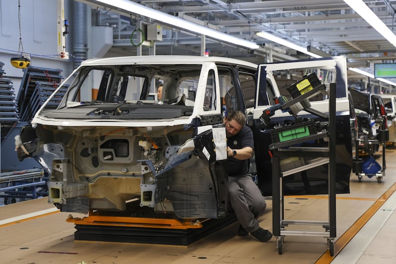 Manufacturing workers assemble a Volkswagen electric vehicle at a plant in Hannover, Germany. Bloomberg