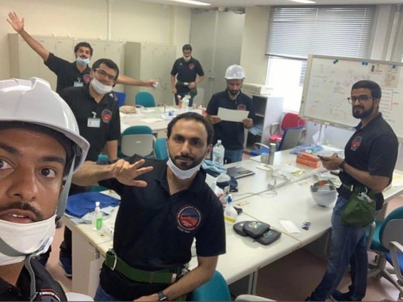 Emirati engineers wave in a picture taken on Sunday from Japan's Tanegashima Space Centre. Courtesy: Emirates Mars Mission / UAE Space Agency