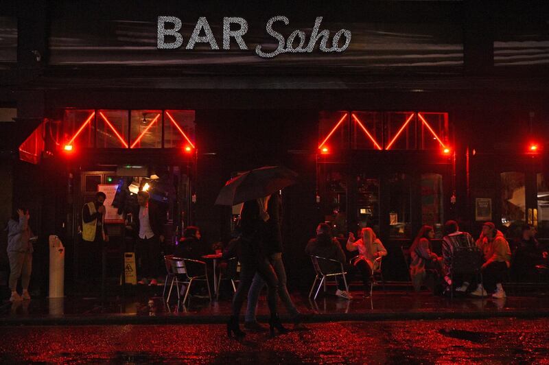 People drink outside a bar in Soho, London, ahead of the 10pm curfew pubs and restaurants are subject to in order to combat the rise in coronavirus cases in England, Friday, Oct. 2, 2020. (Kirsty O'Connor/PA via AP)