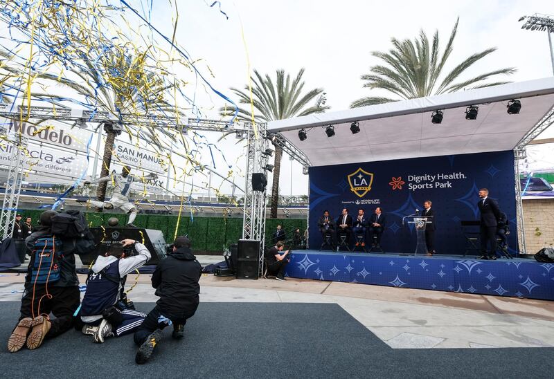 David Beckham, back right, looks on as he unveils a statue of himself. AP Photo