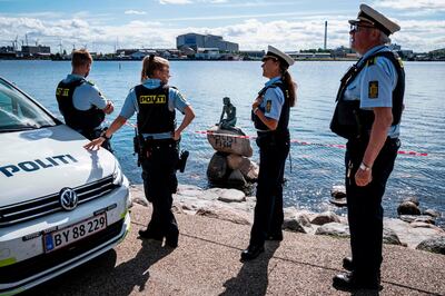 Policemen stand on July 3, 2020 in front of the "Little Mermaid" sculpture after it has been vandalised in Copenhagen.  - Denmark OUT
 / AFP / Ritzau Scanpix / Niels Christian Vilmann
