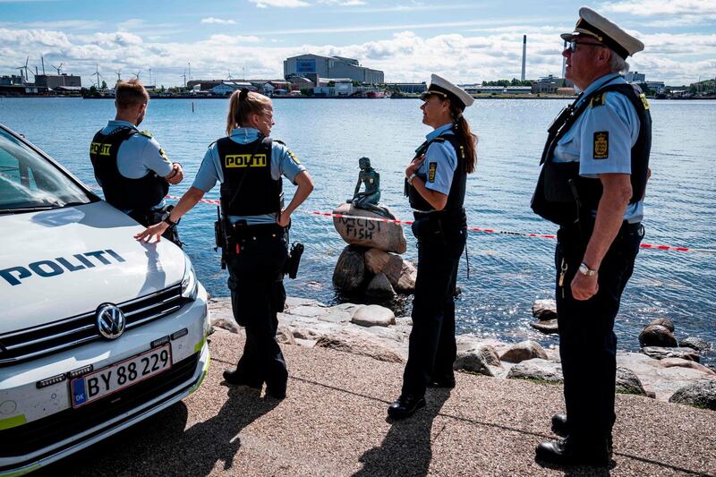 Policemen stand on July 3, 2020 in front of the "Little Mermaid" sculpture after it has been vandalised in Copenhagen.  - Denmark OUT
 / AFP / Ritzau Scanpix / Niels Christian Vilmann
