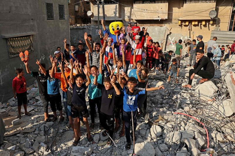 Palestinian children are entertained amid the rubble. AFP