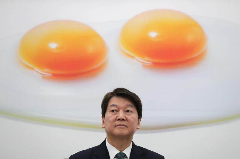 Ahn Cheol-soo, chief of South Korea's minor opposition People's Party, sits in front of a picture bearing an image of a fried egg with a double yolk as he attends a meeting of the party's Supreme Council members at the National Assembly in Seoul.  Yonhap / EPA