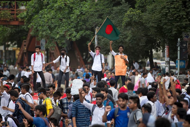 A Bangladeshi student waves the national flag and shouts slogans as they block a road during a protest in Dhaka, Bangladesh. AP Photo / A. M. Ahad