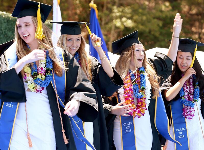 WESTWOOD, CALIFORNIA - JUNE 11: Graduating UCLA students celebrate while walking the stage for their commencement ceremony at Drake Stadium on June 11, 2021 in Westwood, California. Up to 230 students per hour were able to participate in the graduate procession. Each graduate was allowed two guests and were permitted to remove their masks before crossing the stage.   Mario Tama/Getty Images/AFP
== FOR NEWSPAPERS, INTERNET, TELCOS & TELEVISION USE ONLY ==
