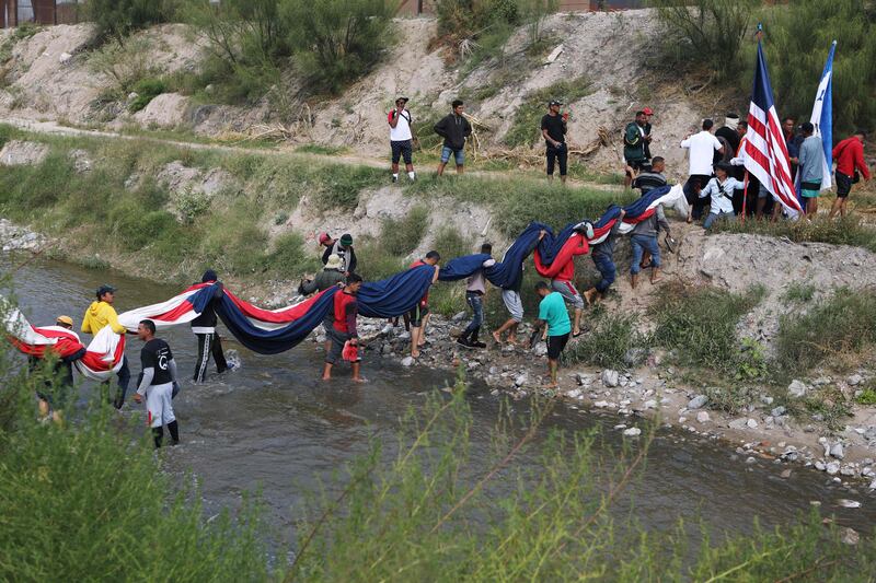 Venezuelan migrants cross the Rio Bravo to hold a demonstration against US immigration policies in Ciudad Juarez, Mexico. AFP