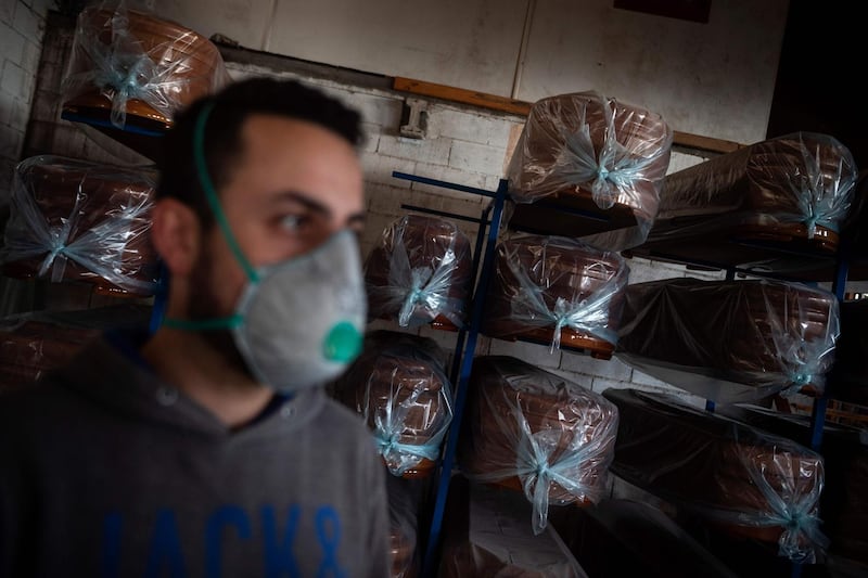 An employee stands in front of coffins stacked at the Yago Gonzalez coffin-making factory in Pinor, northwestern Spain.  AFP