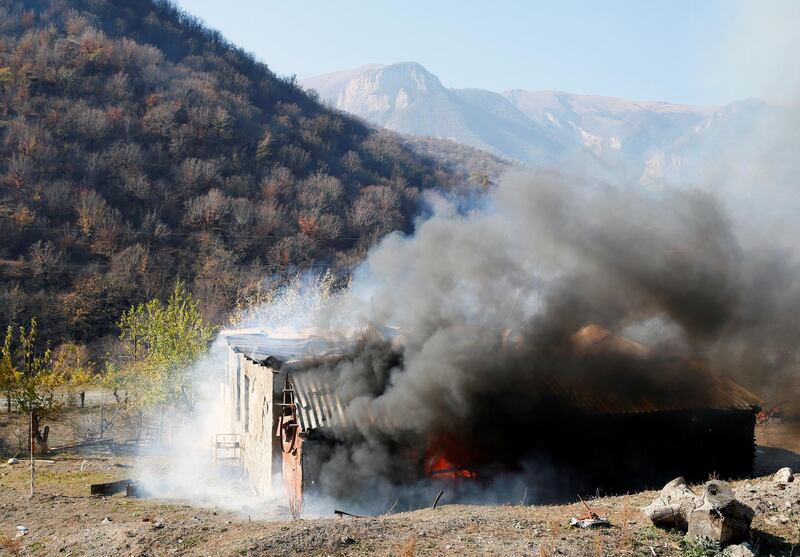 A house is seen set on fire by departing Ethnic Armenians, in an area which is soon to be turned over to Azerbaijan, in the village of Cherektar.  Reuters