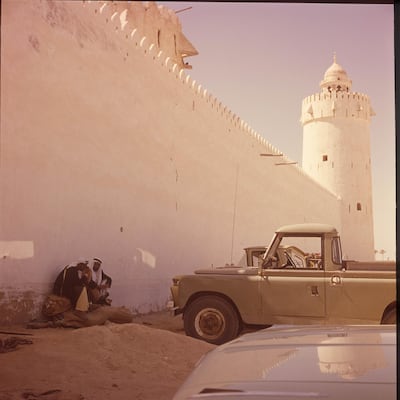 Outside the walls of Qasr Al Hosn in about 1962, Sheikh Zayed chats to a member of his family with a Land Rover Series 2 in the foreground. Photo: Guy Gravette