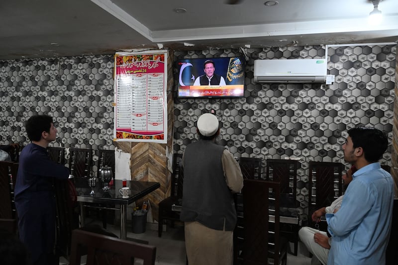 People listen to Pakistan's Prime Minister Imran Khan addressing the nation on television at a restaurant in Islamabad. AFP