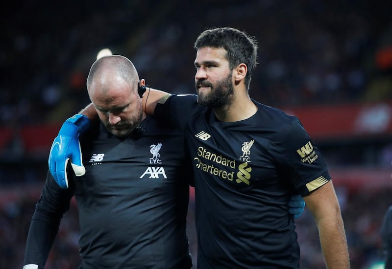 Alisson Becker is helped off the pitch after his injury. Reuters