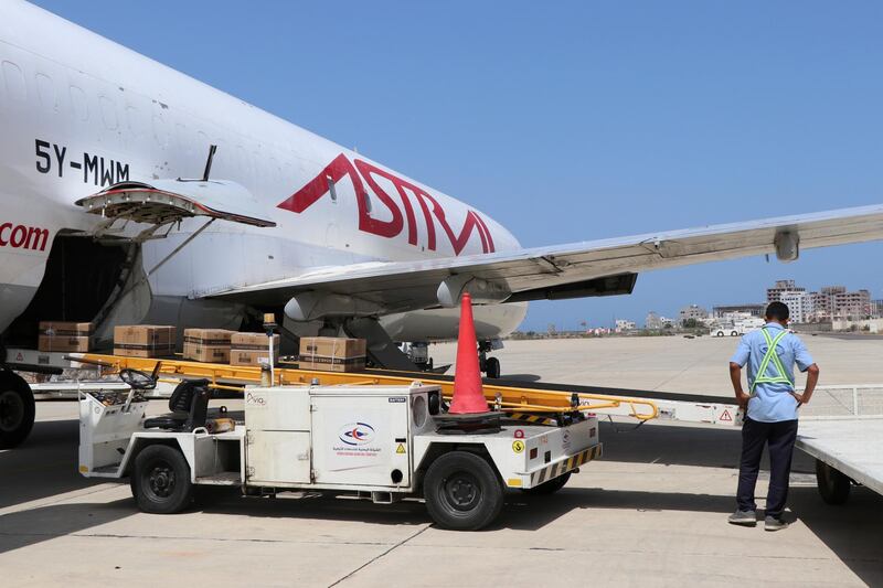 An airport worker unloads boxes containing coronavirus vaccines at the airport in Aden, Yemen. AP Photo