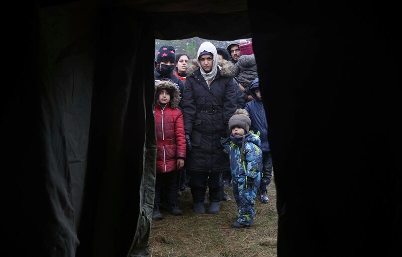 Migrants queue to receive humanitarian aid as they gather at the  border near Grodno. AP Photo