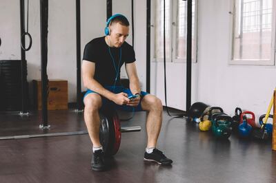 Man with headphones in the gym using phone. Getty Images