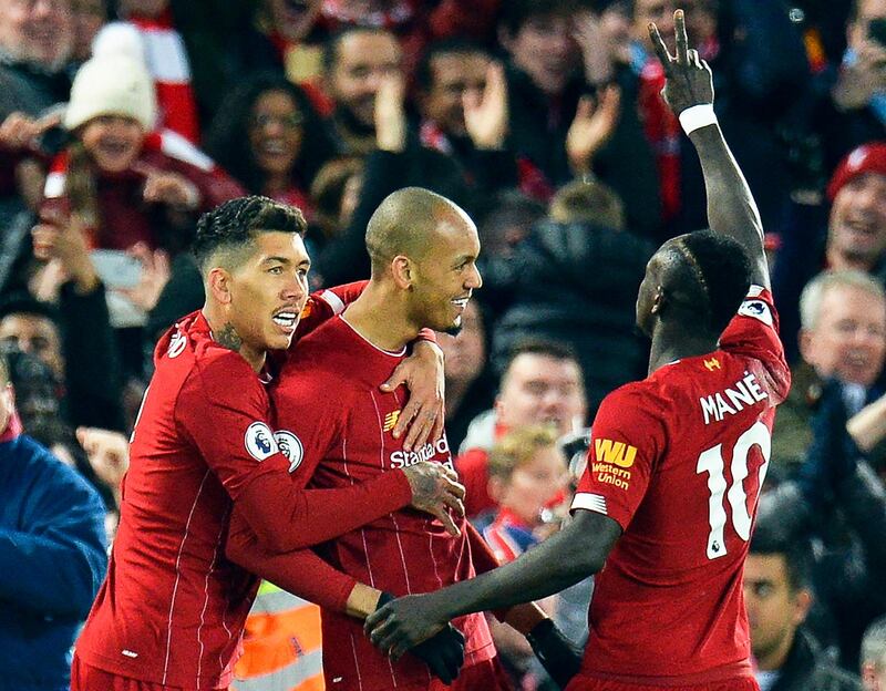 Fabinho, centre, celebrates with Roberto Firmino and Sadio Mane after scoring the first goal against Manchester City in Liverpool.  EPA