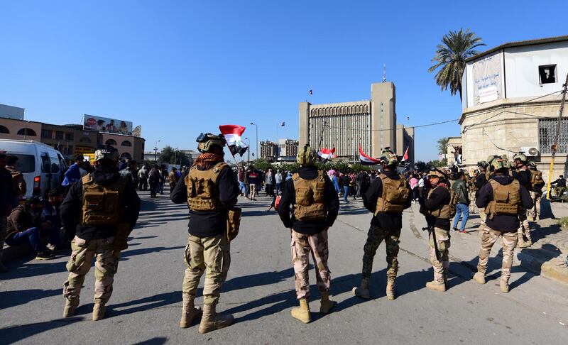 Iraqi soldiers stand guard as Iraqi university students chant slogans as they take part in a demonstration in front of the Iraqi ministry of higher educations in Baghdad, Iraq, 14 January 2020. EPA