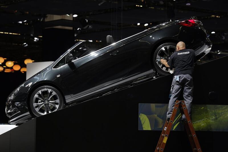 An employee stands on a ladder as he polishes the alloy wheel of a Opel convertible automobile,at the 65th Frankfurt International Motor Show in Frankfurt. Jason Alden / Bloomberg