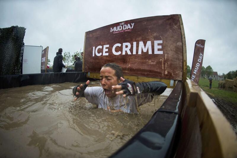 Runners take part in 'The Mud Day challenge', a 13-kilometre obstacles course, on in Beynes near Paris, on Saturday. Martin Bureau / AFP