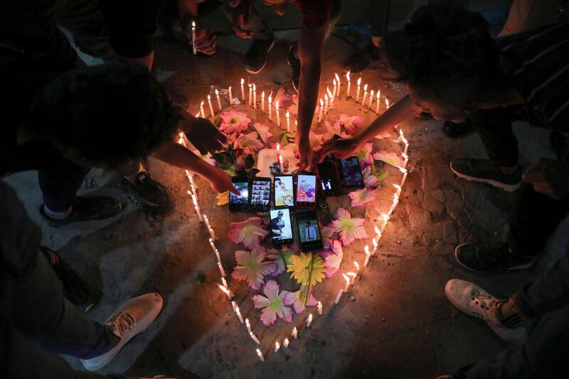 People put their phones inside a heart-shaped decoration made of lit-up candles in the Iraqi city of Karbala on March 28, 2021. Reuters