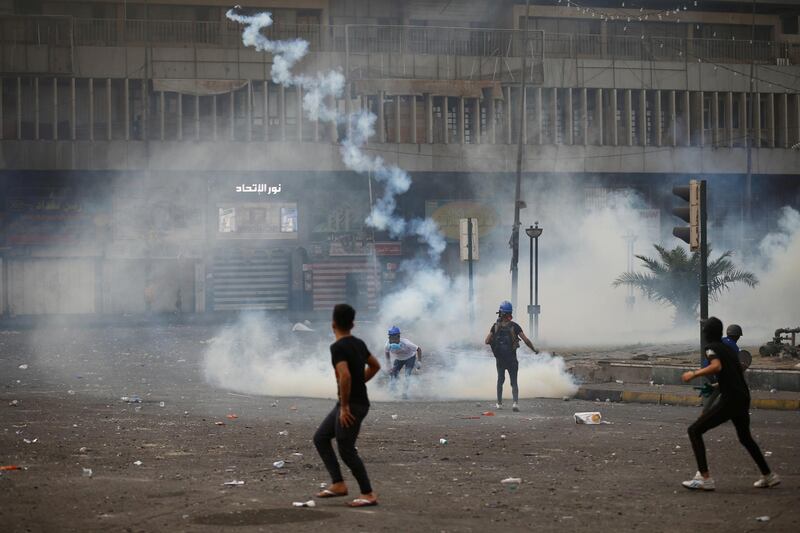 A demonstrator throws away a tear gas canister during the ongoing anti-government protests in Baghdad, Iraq. Reuters