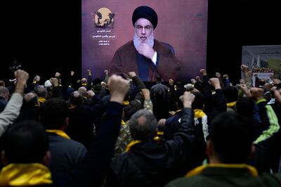 Hezbollah supporters raise their fists and cheer as they listen to a speech by Hassan Nasrallah via video link on Tuesday. AP Photo