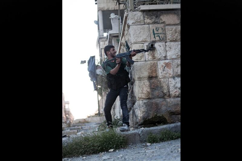 An FSA soldier shoots his weapon towards Syrian Army positions in the Izaa district. Manu Brabo / AP Photo