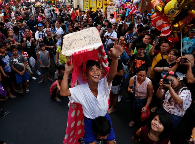 Filipino children perform with dragon costumes in front of revellers in Manila's Chinatown. Francis R Malasig / EPA
