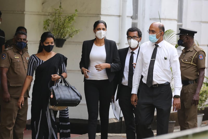 Former Mrs World Caroline Jurie, centre, flanked by her lawyers walk out of the Cinnamon Gardens Police station. EPA