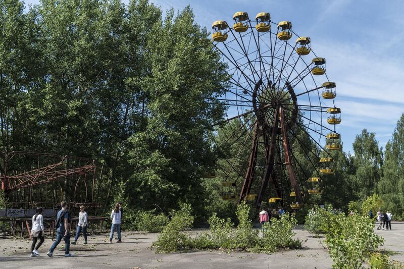 Tourists take pictures at a rusty ferris wheel, one of the most famous landmarks in Pripyat. Getty Images