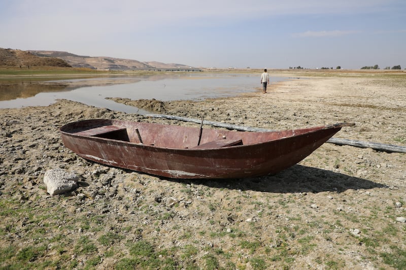 A boat lies on the dry shores of the Euphrates in Syria, where levels at dams on the river have fallen by up to 5 metres, shrinking reservoirs and leaving farmers struggling to access the remaining water reserves