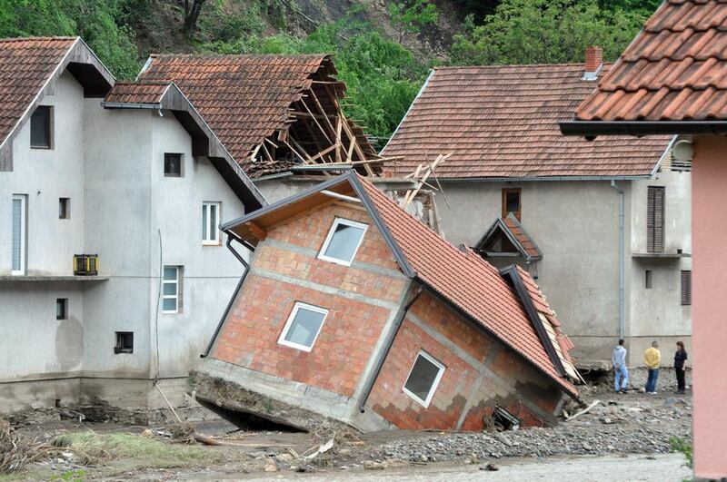 People standing near damaged houses after flooding in Krupanj, 150km south-east of Belgrade, Serbia. Dragan Karadarevic / EPA