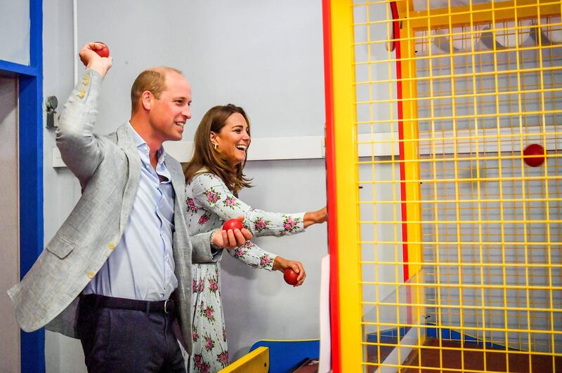 BARRY, WALES - AUGUST 05:  Prince William, Duke of Cambridge and Catherine, Duchess of Cambridge throw balls to knock down figures on an arcade game at Island Leisure Amusement Arcade, where Gavin and Stacey was filmed, during their visit to Barry Island, South Wales, to speak to local business owners about the impact of COVID-19 on the tourism sector on August 5, 2020 in Barry, Wales. (Photo by Ben Birchall - WPA Pool/Getty Images)
