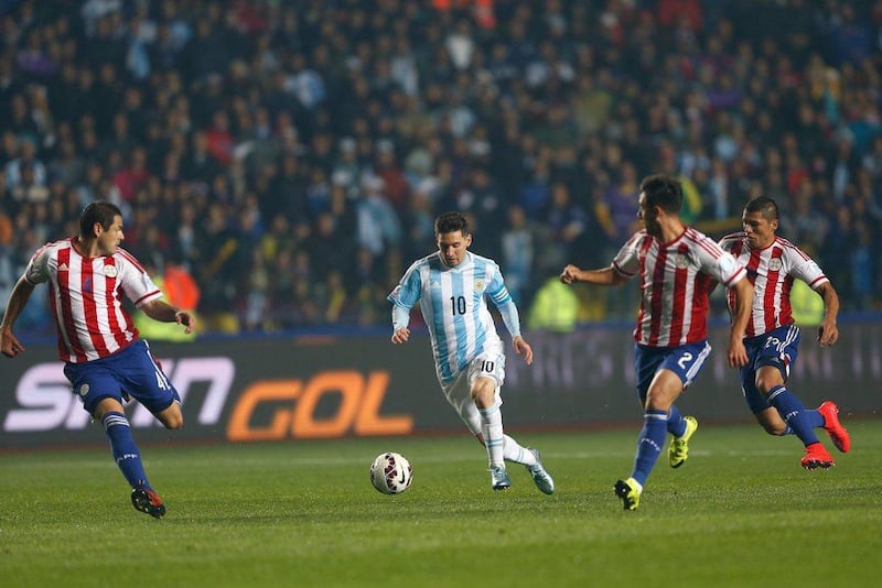 Argentina's Lionel Messi dribbles through Paraguay defenders during the Copa America semi-final on Tuesday night in Concepcion. Andre Penner / AP