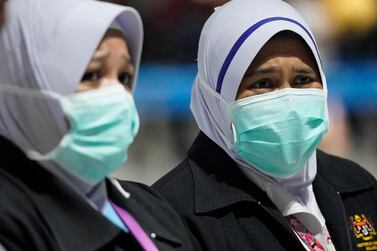 Health officials wear face masks at an inspection site at the Kuala Lumpur International Airport in Sepang, Malaysia. AP