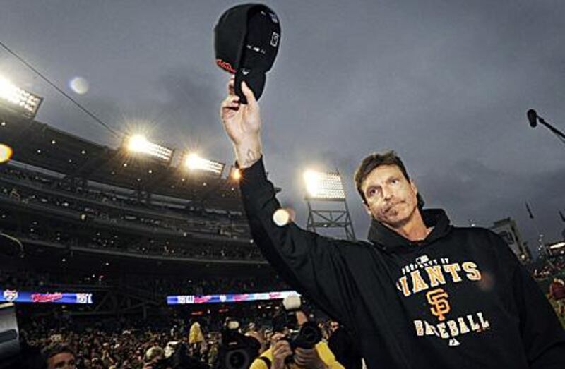 The San Francisco Giants starting pitcher Randy Johnson tips his cap to the crowd after earning his 300th career win.