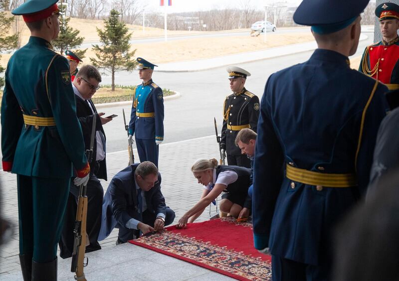 Officials adjust the red carpet prior to the arrival of Russian President Vladimir Putin and North Korea's leader Kim Jong-un in Vladivostok. AP Photo